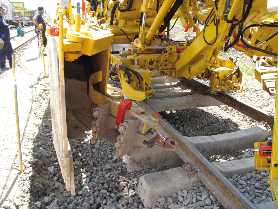 Hydraulically slewing angle connection for installing the chain without infringements of the clearance gauge